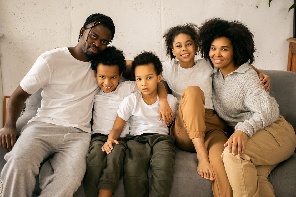 Black parents and their children relaxing together on a sofa